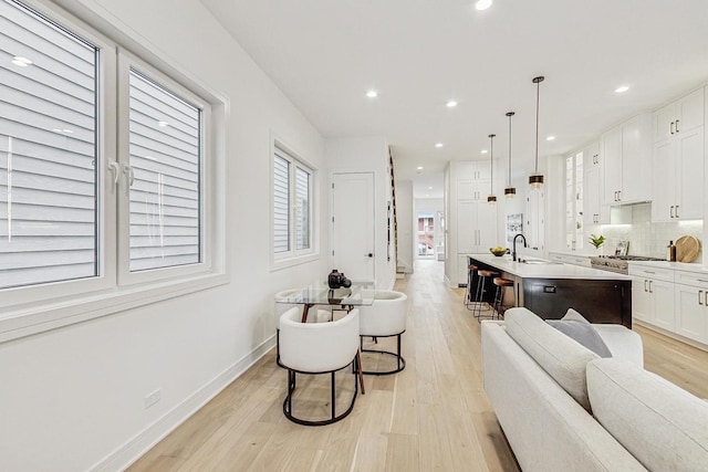 living area featuring light wood finished floors, recessed lighting, and baseboards