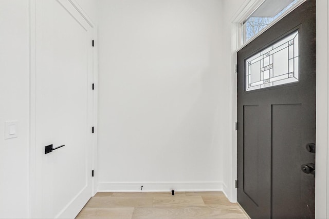 entryway featuring baseboards and light wood finished floors