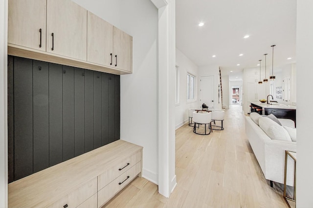 mudroom featuring light wood-style flooring, a sink, and recessed lighting