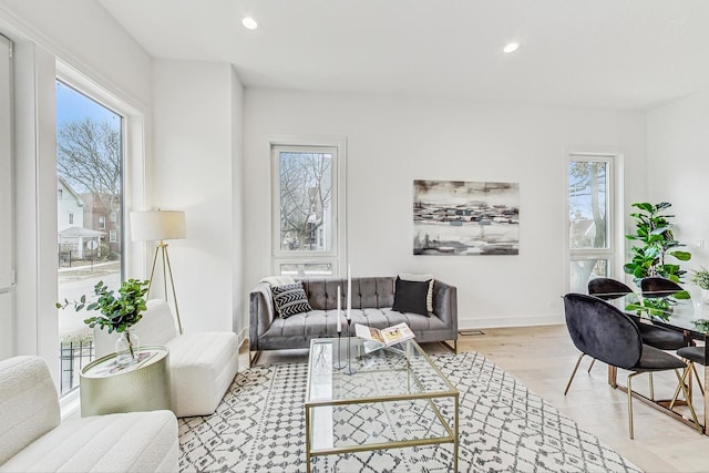 living room featuring light wood-type flooring, plenty of natural light, baseboards, and recessed lighting