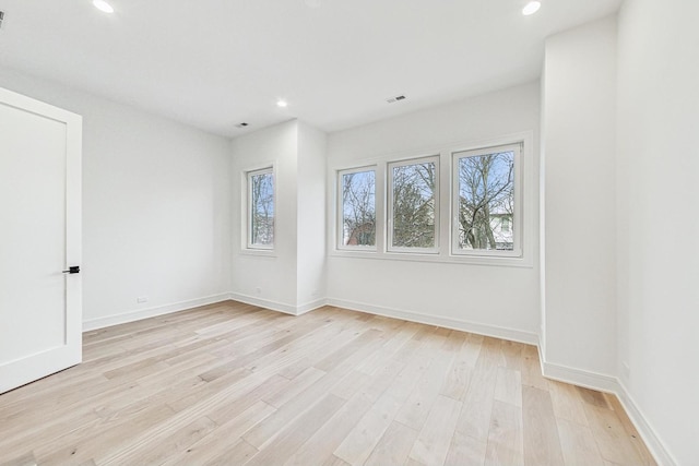 spare room featuring baseboards, light wood finished floors, visible vents, and recessed lighting