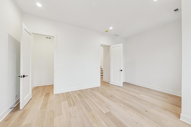 spare room with light wood-style flooring, visible vents, baseboards, and recessed lighting