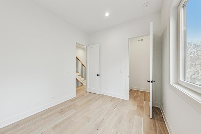 interior space with light wood-type flooring, visible vents, and baseboards