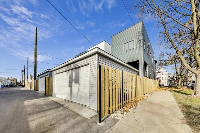 view of side of home featuring a garage and fence