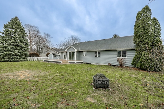 rear view of property with a yard and an outdoor fire pit