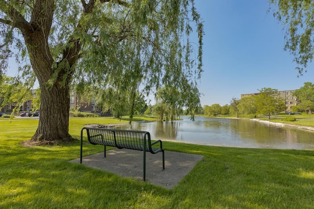 view of property's community featuring a yard and a water view