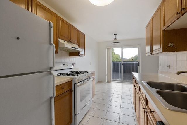 kitchen featuring backsplash, white appliances, sink, pendant lighting, and light tile patterned flooring