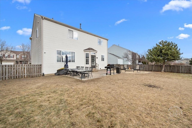 rear view of house with a lawn and a patio