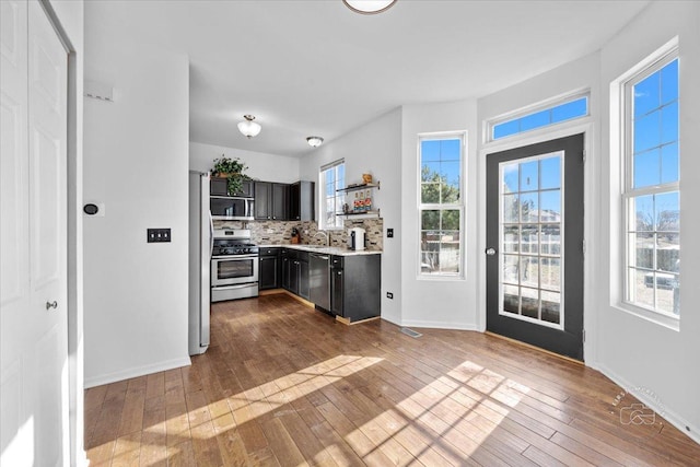 kitchen with decorative backsplash, sink, stainless steel appliances, and light hardwood / wood-style floors