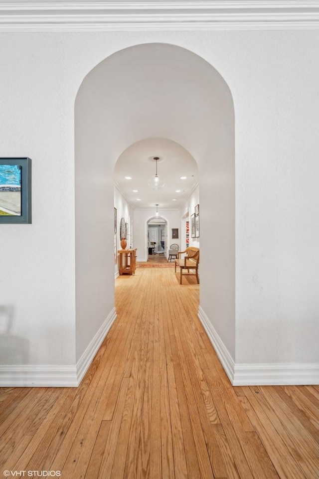 hallway featuring light hardwood / wood-style floors and ornamental molding