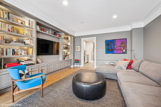 living room with built in shelves, light hardwood / wood-style floors, and ornamental molding