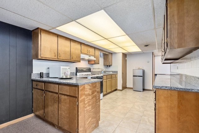 kitchen featuring stainless steel refrigerator, a paneled ceiling, sink, and range