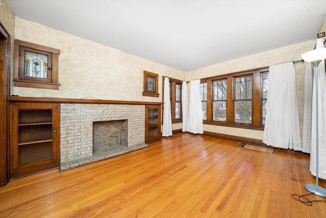 unfurnished living room with a fireplace and wood-type flooring