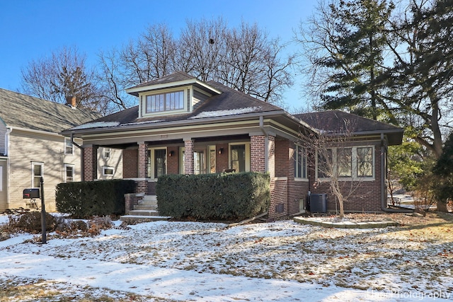 bungalow-style home with a porch and central air condition unit