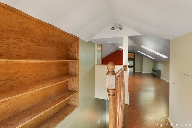 bonus room featuring lofted ceiling with skylight and dark hardwood / wood-style flooring