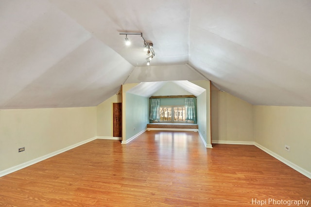 bonus room featuring vaulted ceiling and light wood-type flooring