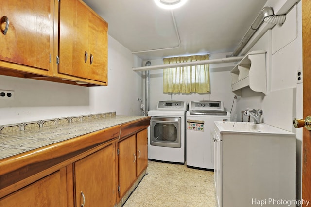 clothes washing area featuring cabinets and washing machine and clothes dryer