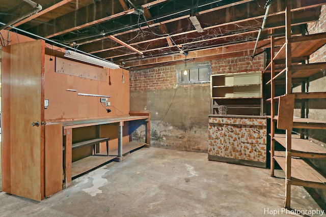 basement featuring brick wall and a workshop area