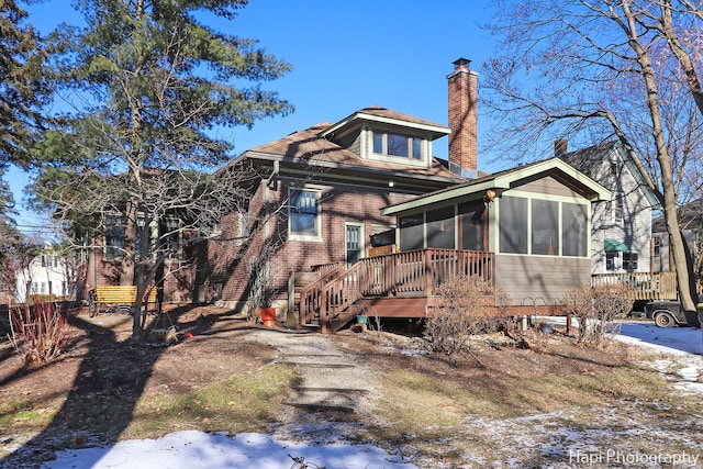 snow covered property with a sunroom