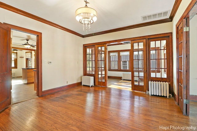 spare room with french doors, radiator heating unit, and hardwood / wood-style floors