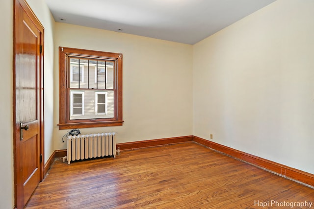 unfurnished room with radiator and dark hardwood / wood-style flooring