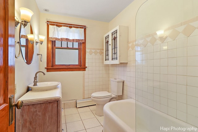 bathroom with vanity, tile patterned flooring, tile walls, a baseboard heating unit, and a tub