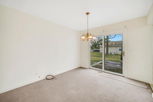 carpeted spare room featuring a notable chandelier