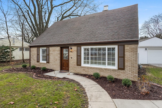 view of front of home with a front yard, an outbuilding, and a garage