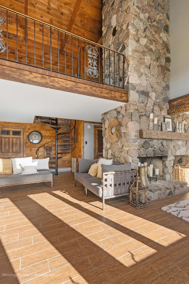 unfurnished living room with high vaulted ceiling, a stone fireplace, hardwood / wood-style flooring, beamed ceiling, and wood ceiling