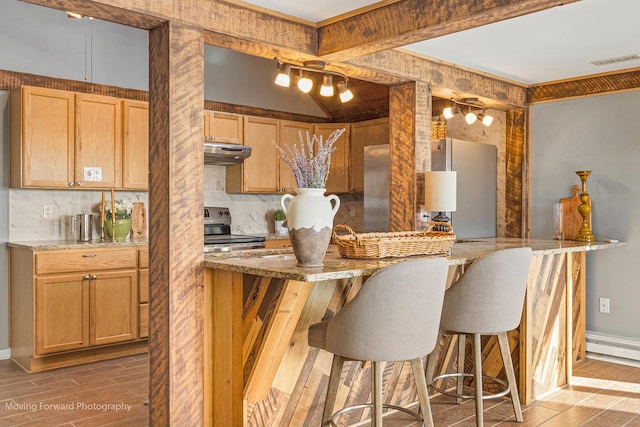 kitchen with stainless steel range with electric cooktop, white refrigerator, light stone countertops, tasteful backsplash, and kitchen peninsula