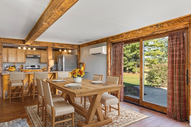 dining space with beam ceiling, light hardwood / wood-style flooring, and a wall mounted air conditioner