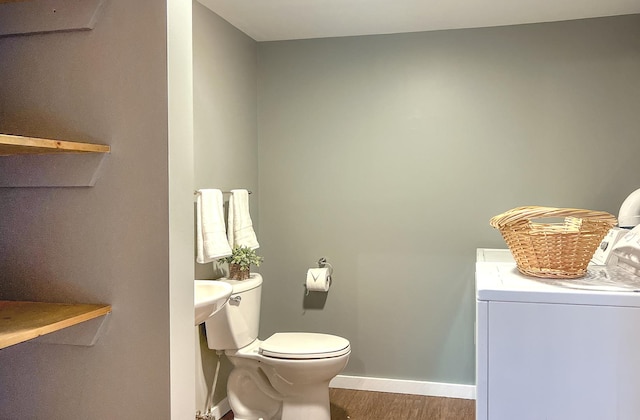 bathroom with hardwood / wood-style floors, toilet, and washer / clothes dryer