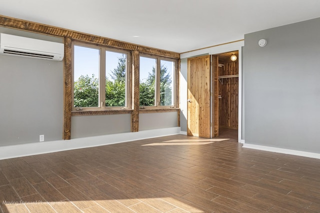 unfurnished room featuring hardwood / wood-style flooring and a wall unit AC