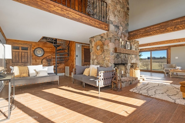 unfurnished living room featuring hardwood / wood-style flooring, a stone fireplace, and wooden walls