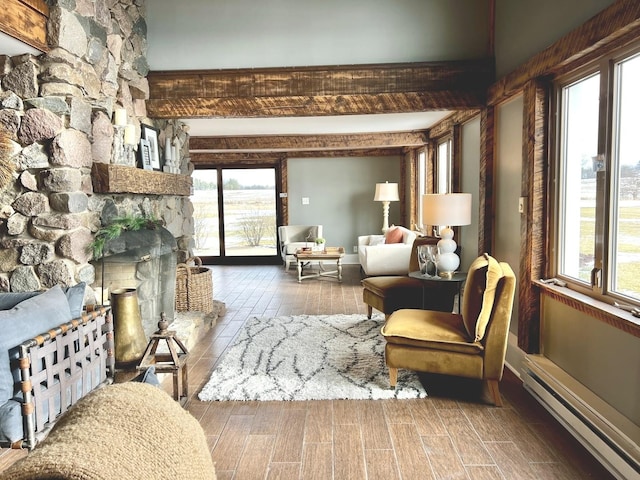 living area featuring baseboard heating, a stone fireplace, and beamed ceiling