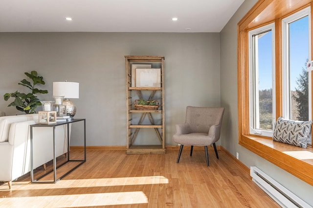 sitting room with light hardwood / wood-style flooring and a baseboard heating unit