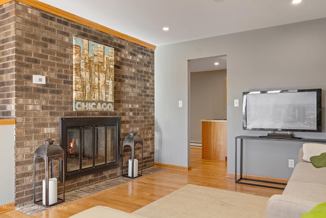 living room featuring a fireplace, a baseboard radiator, and hardwood / wood-style flooring