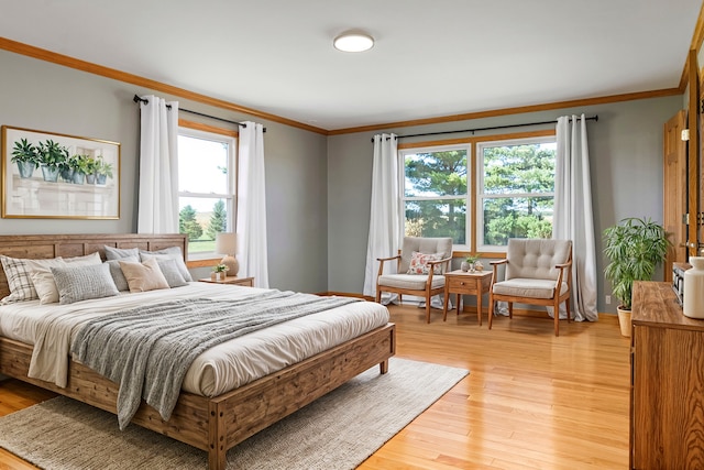 bedroom with light wood-type flooring and crown molding