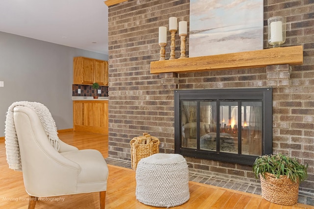 sitting room featuring light hardwood / wood-style floors and a brick fireplace