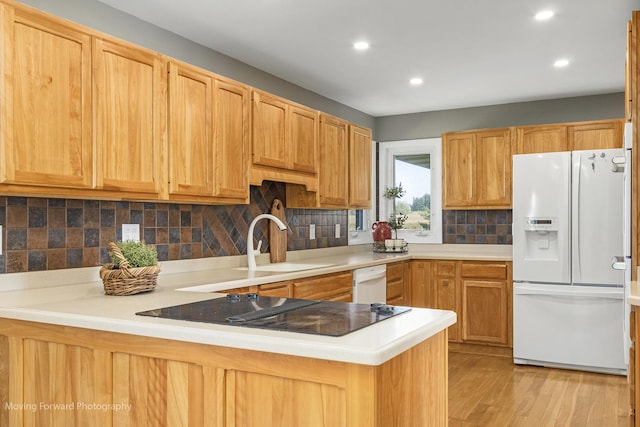 kitchen with light hardwood / wood-style floors, sink, white appliances, and kitchen peninsula