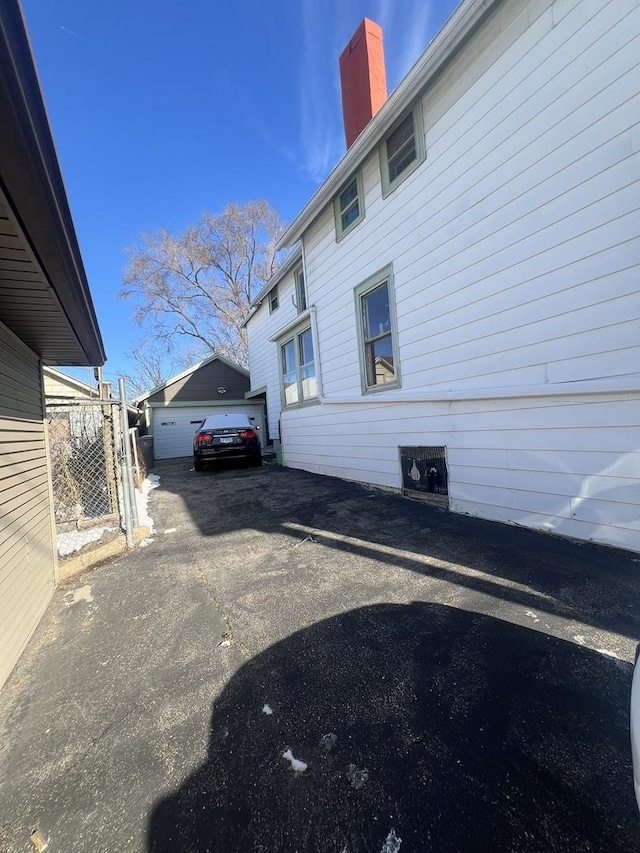 view of side of home featuring an outbuilding and a garage