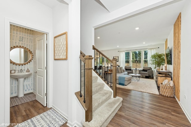 stairway featuring sink and hardwood / wood-style flooring