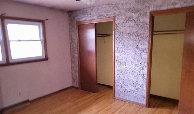 unfurnished bedroom with light wood-type flooring and a closet