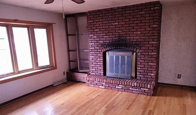 unfurnished living room with a fireplace, hardwood / wood-style floors, and ceiling fan