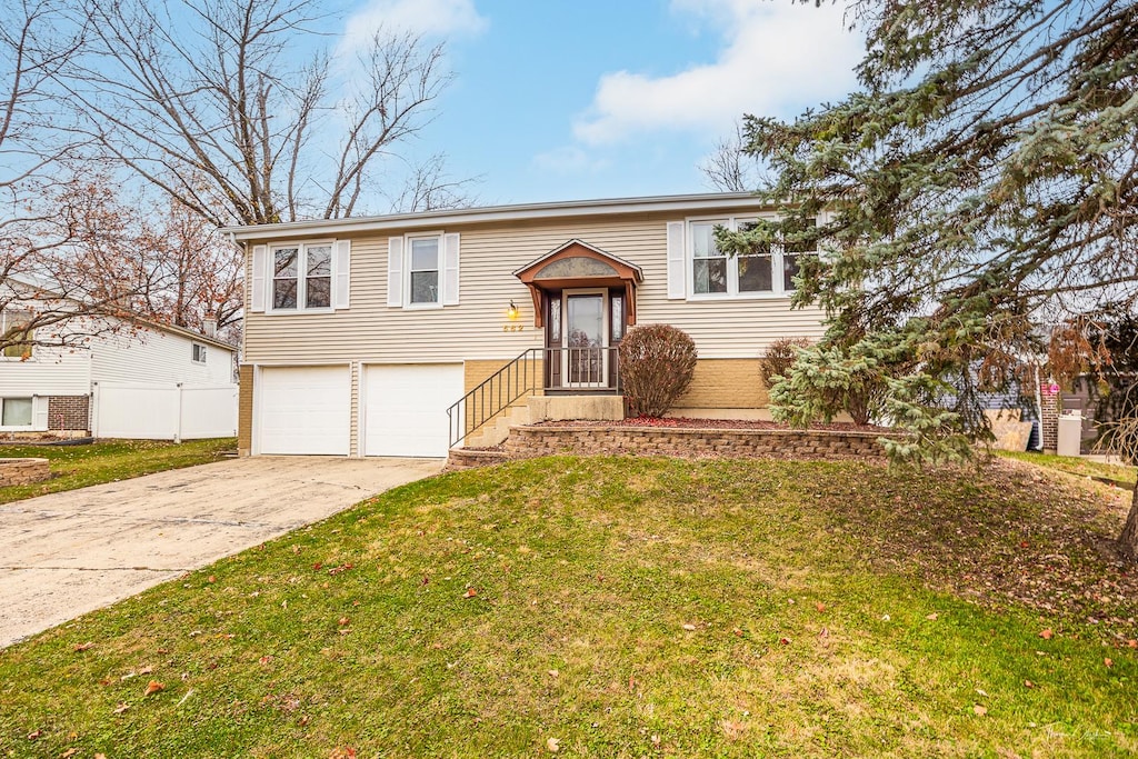 bi-level home with a garage and a front yard