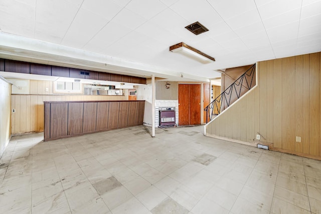 interior space with kitchen peninsula and wooden walls