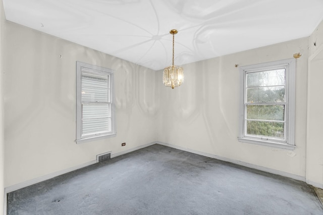 unfurnished room featuring carpet floors and an inviting chandelier