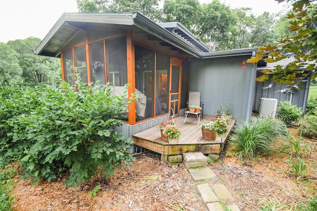 rear view of property with a wooden deck and a sunroom