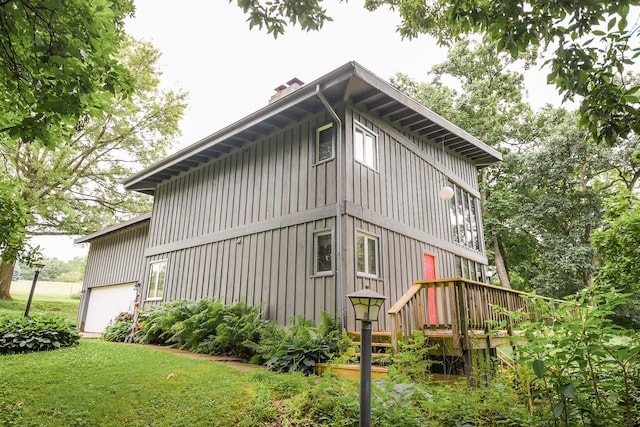 view of property exterior featuring a garage and a lawn