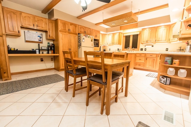 kitchen featuring ceiling fan, sink, light tile patterned floors, white refrigerator, and beam ceiling